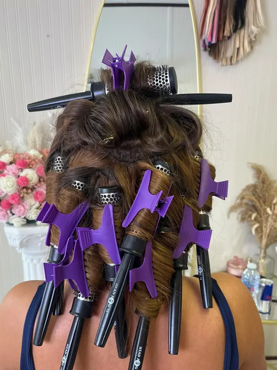 Hair sectioned and clipped into a full pin curl set part way through styling