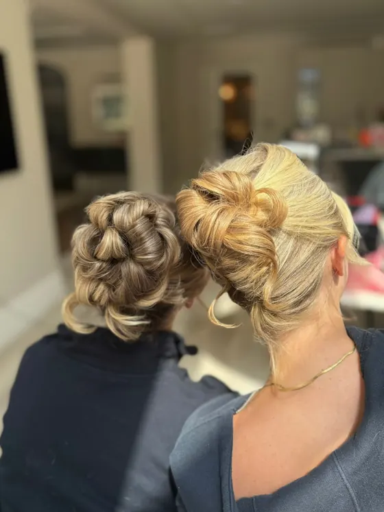 Two clients styled together, both wearing pinned updos